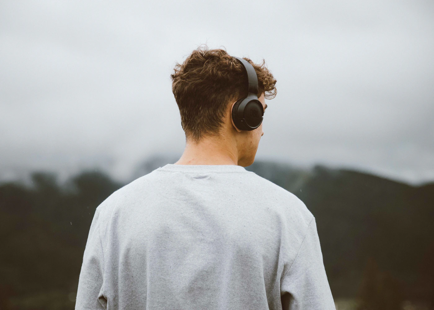 a man with headphones on looking at the mountains