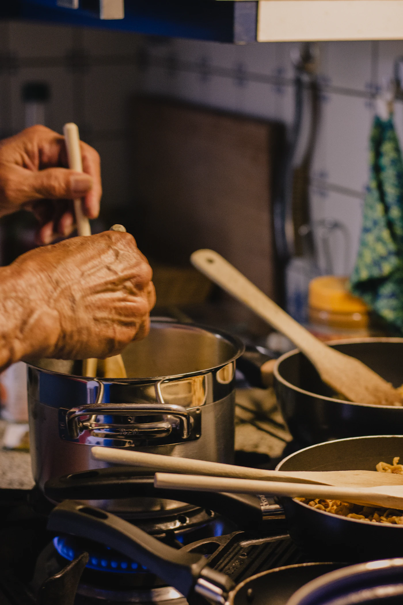 A person mixing batter in a metal bowl while baking at home
